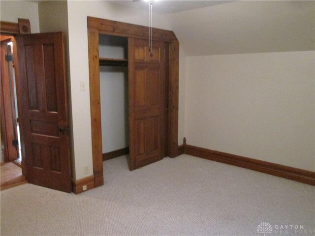 204 N Main St, Lewisburg, OH 45338 - unfurnished bedroom with light carpet, baseboards, lofted ceiling, and a closet