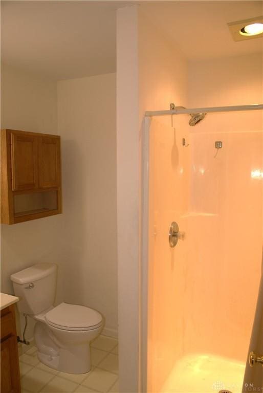 bathroom featuring walk in shower, vanity, toilet, and tile patterned flooring