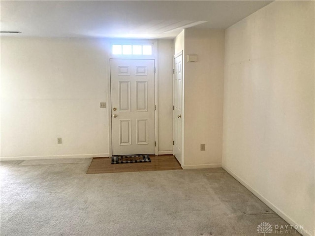 foyer entrance featuring light carpet