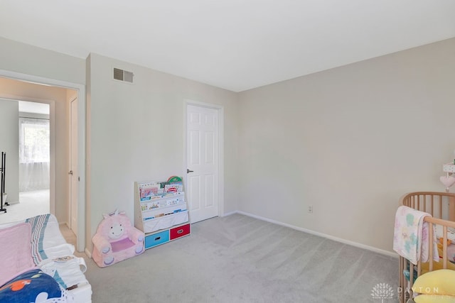 carpeted bedroom with a nursery area