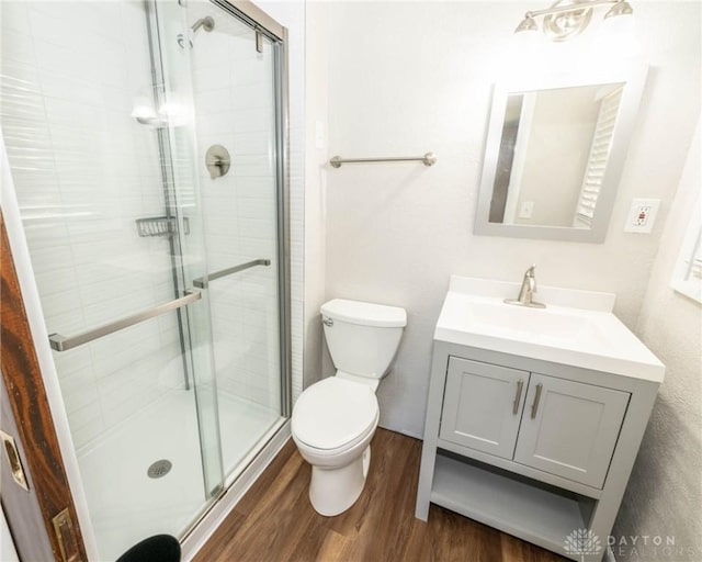 bathroom featuring hardwood / wood-style flooring, vanity, toilet, and an enclosed shower