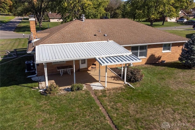 back of property featuring a yard, cooling unit, and a patio