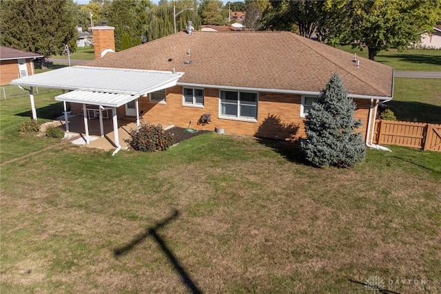 rear view of property featuring a yard and a patio area