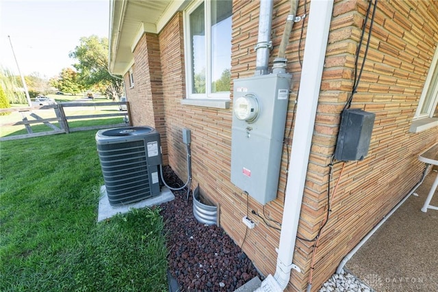 view of property exterior with central AC unit and a yard