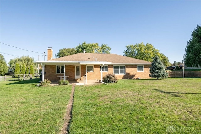 back of house with a lawn and a patio area