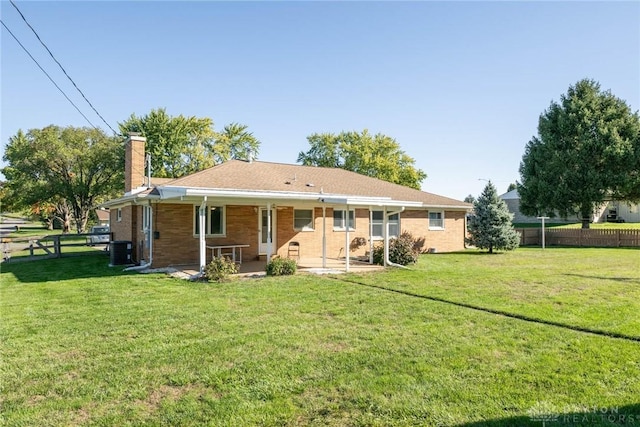 rear view of property featuring a yard and cooling unit