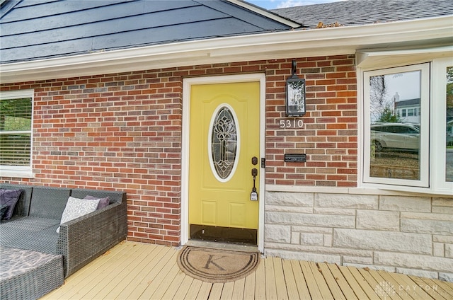 view of exterior entry featuring a wooden deck