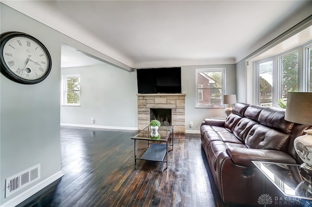 living room with a healthy amount of sunlight, a fireplace, and dark hardwood / wood-style flooring