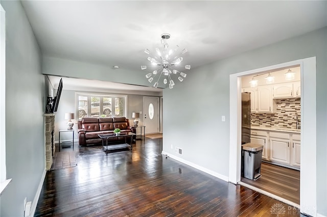 living room with sink, a chandelier, and dark hardwood / wood-style flooring