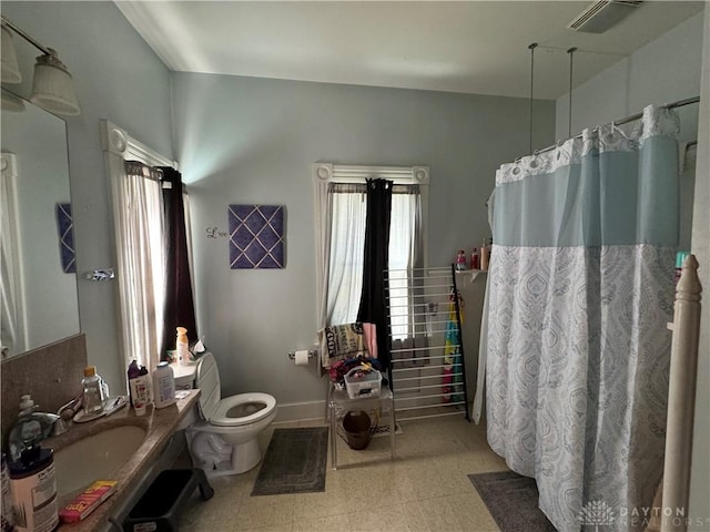 bathroom featuring vanity, curtained shower, and toilet