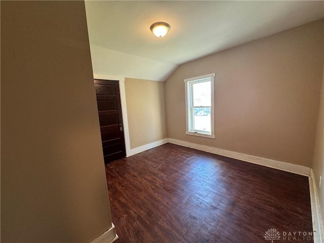 unfurnished room with lofted ceiling and dark hardwood / wood-style flooring