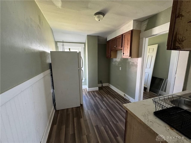 kitchen with white fridge and dark hardwood / wood-style flooring