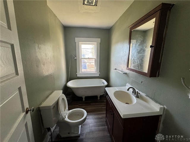 bathroom with vanity, wood-type flooring, a tub, and toilet