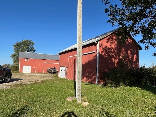 view of side of property featuring an outbuilding and a lawn