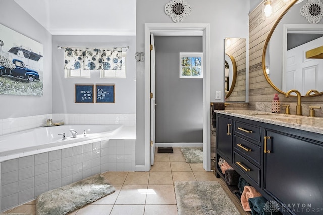 bathroom featuring tile patterned flooring, tiled tub, and vanity