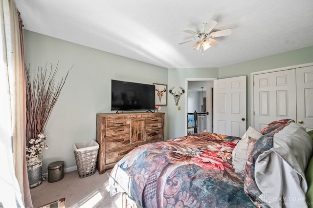 carpeted bedroom featuring ceiling fan and a closet