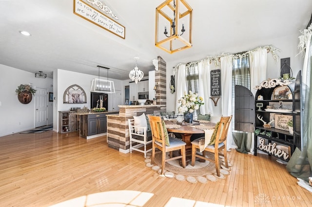 dining room with light wood-type flooring and a chandelier