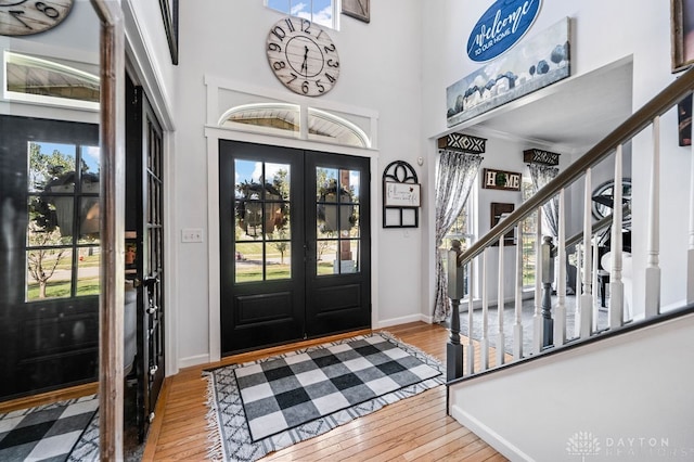 foyer entrance with french doors, hardwood / wood-style flooring, and a healthy amount of sunlight