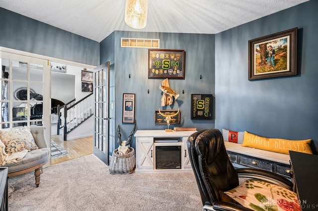 home office featuring a fireplace, french doors, wood-type flooring, and a textured ceiling