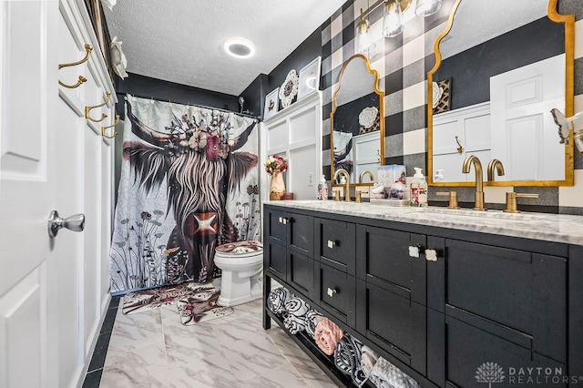 bathroom featuring a shower with curtain, vanity, toilet, and a textured ceiling