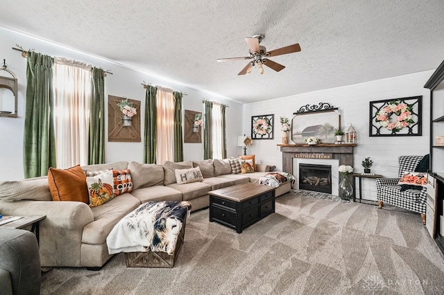 living room with ceiling fan, carpet, and a textured ceiling