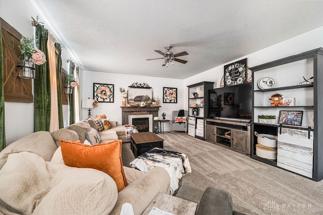 carpeted living room featuring ceiling fan and a textured ceiling