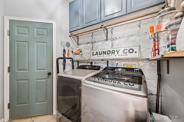 laundry area with separate washer and dryer, cabinets, and light tile patterned flooring