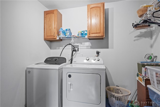 laundry room with independent washer and dryer and cabinets