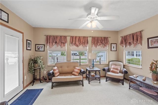 sitting room with a textured ceiling, ceiling fan, and carpet flooring