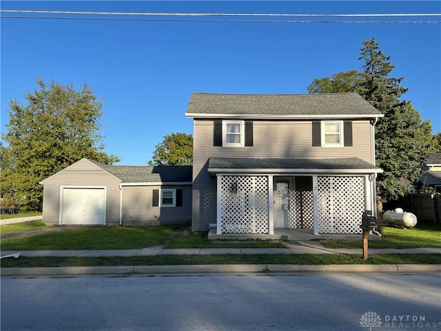 view of front of house featuring a front lawn, a porch, an outdoor structure, and a garage