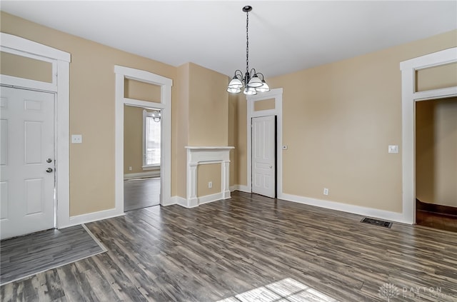 unfurnished dining area with a notable chandelier and dark hardwood / wood-style floors