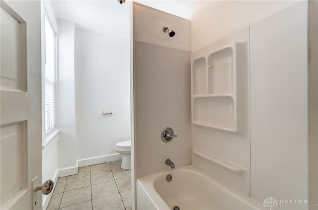 bathroom featuring bathing tub / shower combination, tile patterned flooring, and toilet