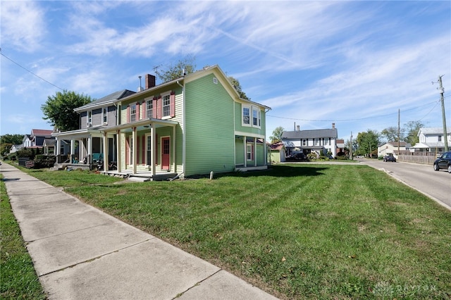 view of side of home with a yard and covered porch