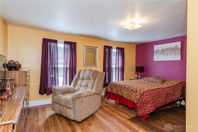 bedroom with wood-type flooring and multiple windows