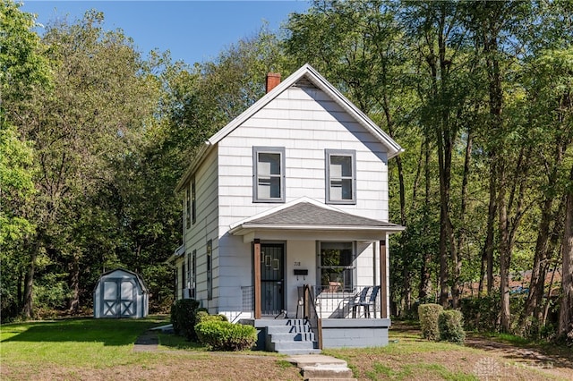 front facade featuring a storage shed, a front lawn, and covered porch