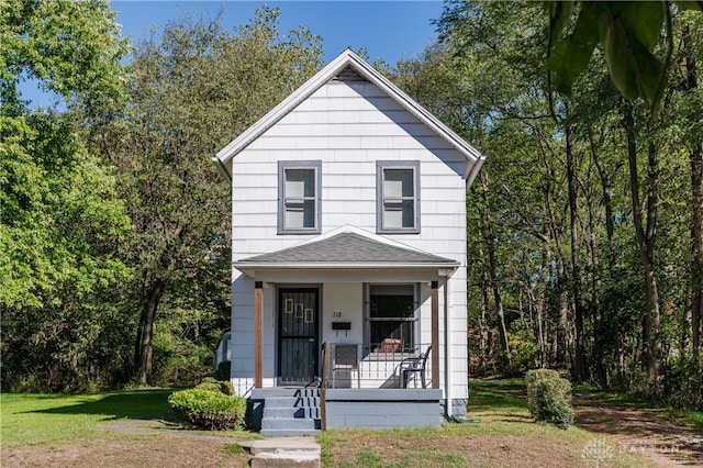 view of property featuring a porch and a front yard