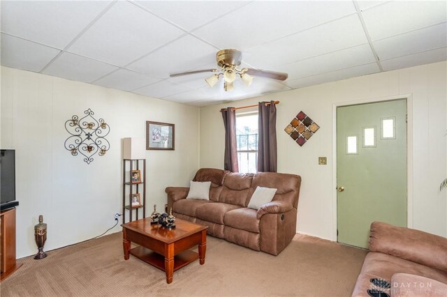 carpeted living room with a drop ceiling and ceiling fan