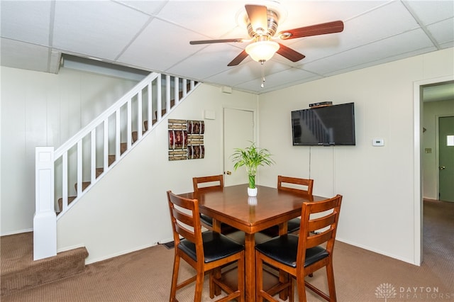 dining room with ceiling fan, a paneled ceiling, and carpet flooring