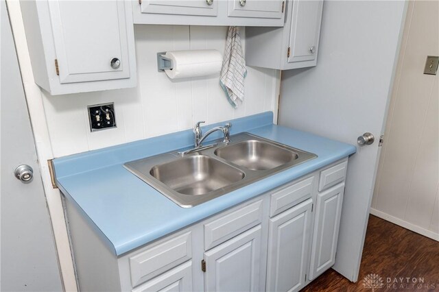 kitchen featuring dark wood-type flooring, sink, and white cabinetry