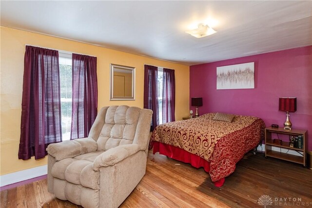 bedroom with multiple windows and hardwood / wood-style floors