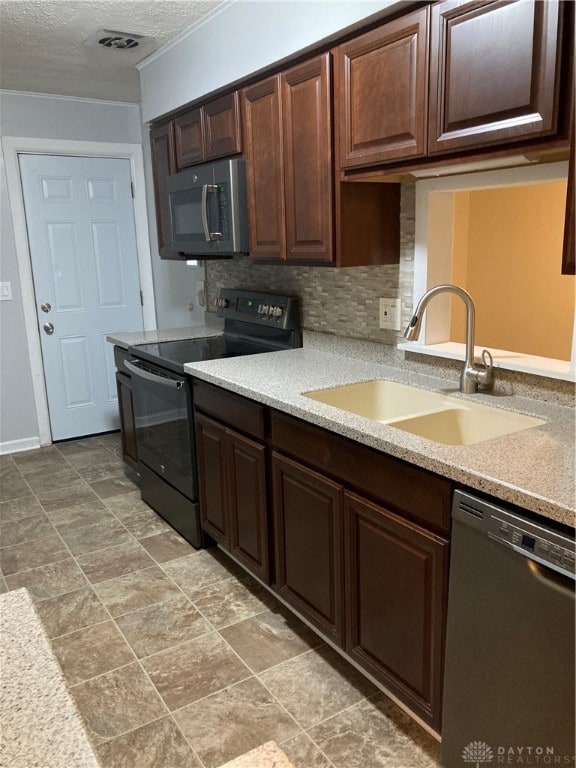 kitchen featuring dark brown cabinetry, stainless steel appliances, sink, and tasteful backsplash