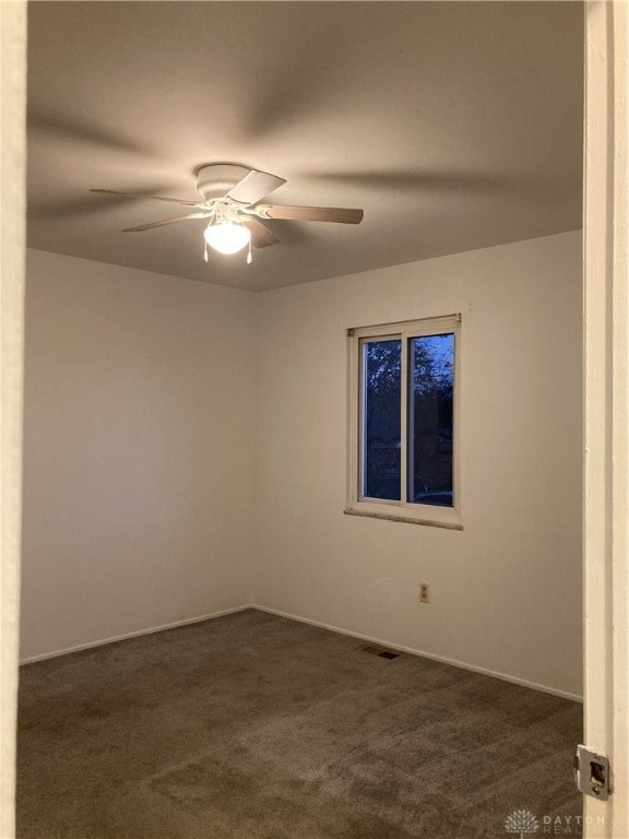 carpeted spare room with ceiling fan