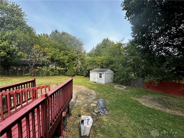 view of yard with a shed, a fire pit, and a wooden deck