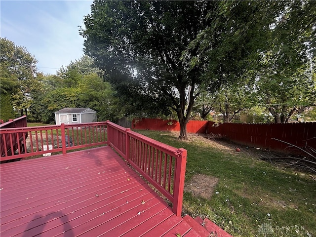 wooden deck featuring a storage shed and a yard