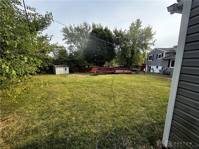 view of yard featuring a shed and a wooden deck