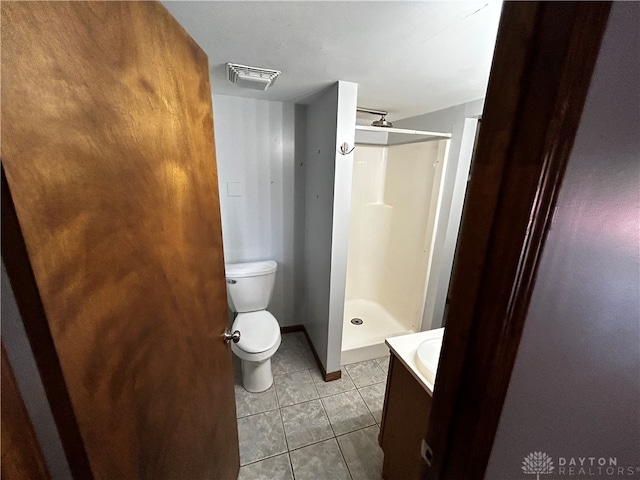 bathroom with tile patterned flooring, a shower, vanity, and toilet