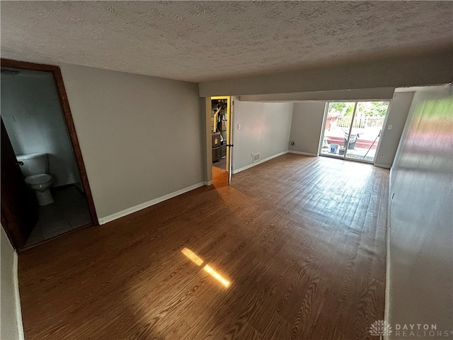 unfurnished room featuring hardwood / wood-style flooring and a textured ceiling