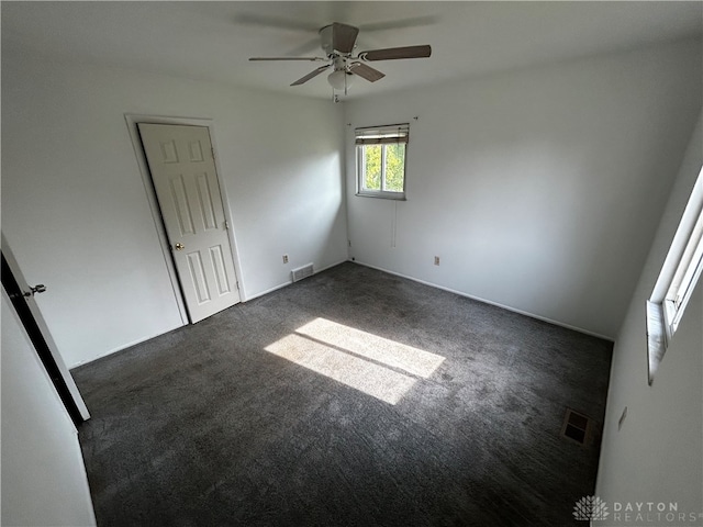 carpeted spare room featuring ceiling fan