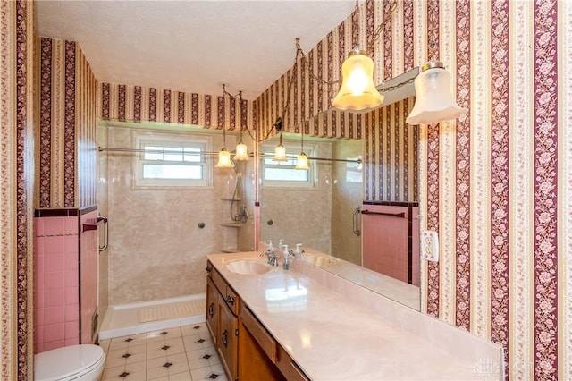 bathroom featuring a textured ceiling, vanity, tile patterned floors, and a shower with shower door