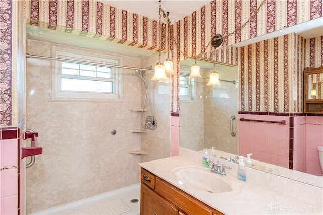 bathroom featuring tiled shower and vanity